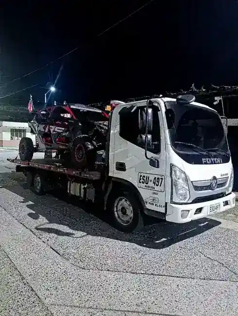 Grúa VehiGruas ESU-497 transportando SUV en carretera del Eje Cafetero